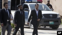 Zakarya Ahmad Al-Fattah (R), brother of Osama bin Laden's youngest widow, Yemen-born Amal Al-Sadeh, arrives with their lawyer Amir Khalil (L) to attend court proceedings at a house where bin Laden's family is believed to be detained in Islamabad April 2, 