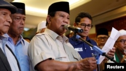 Indonesia's presidential candidate Prabowo Subianto delivers a speech to declare election victory as his running mate Sandiaga Uno stands next to him in Jakarta, Indonesia, April 18, 2019. 