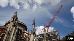 A picture taken on August 19, 2019 shows a crane at the cathedral of Notre-Dame of Paris worksite, as works to restore the cathedral following a devastating fire in April resumed, after lead scare. French workers on August 19 resumed efforts to…