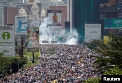 지난 26일 베네수엘라 수도 카르카스에서 니콜라스 마두로 대통령 퇴진을 요구하는 대규모 시위가 계속됐다. 시위대 뒤편으로 경찰이 발사한 최루가스가 보인다.