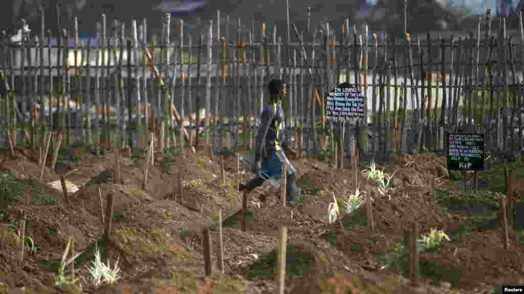 Un fossoyeur marche à travers les fosses nouvellement creusées pour l&rsquo;enterrement des victimes d&#39;Ebola dans un cimetière de Freetown, 4 décembre 2014. REUTERS / Baz Ratner