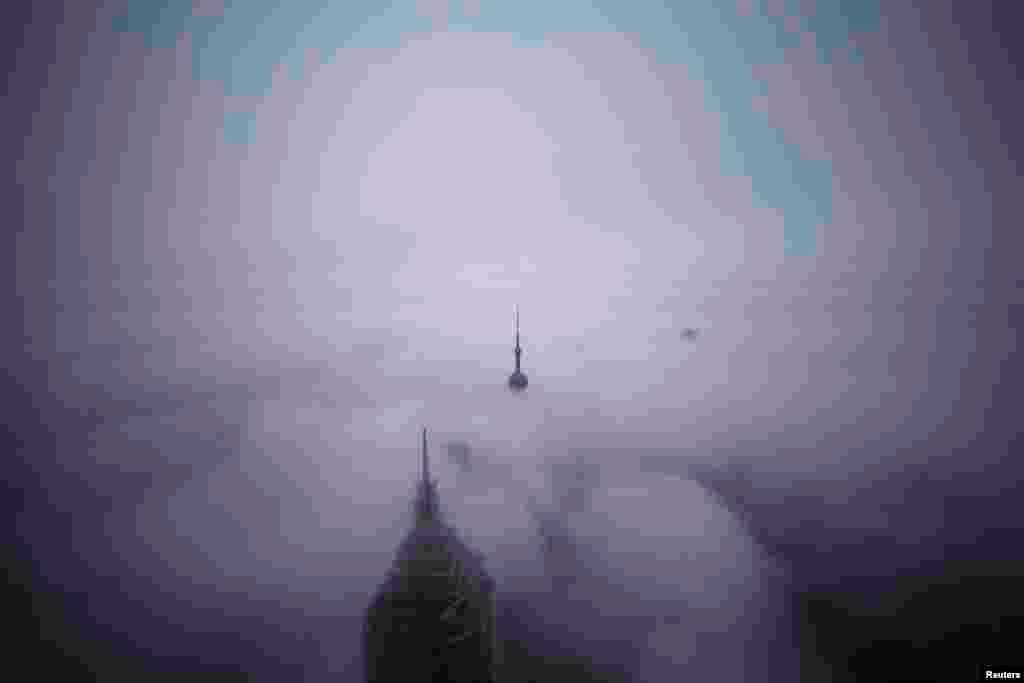 Skyscrapers Oriental Pearl Tower and Jin Mao Tower (L) are seen from the Shanghai World Financial Center during rain at the financial district of Pudong in Shanghai, China.