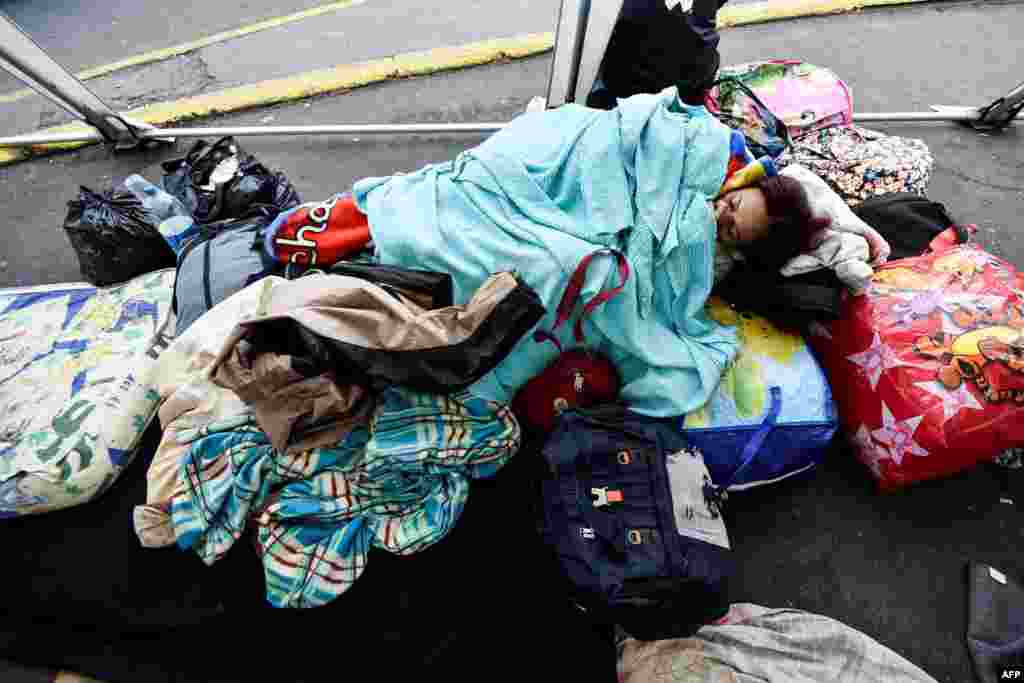 A Venezuelan migrant rests outside the Ecuadorean migrations office at the Rumichaca International Bridge, in the border between Tulcan, Ecuador, and Ipiales, Colombia.