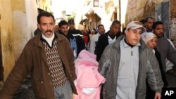 Residents of the Tizimi neighborhood in Meknes' old quarter carry from the morgue a victim of the collapse of a historic minaret, February 20, 2010