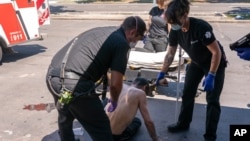 Salem Fire Department Capt. Matt Brozovich, left, and Falck Northwest ambulance personnel help treat a man experiencing heat exposure at a cooling center during a heat wave, June 26, 2021, in Salem, Oregon.