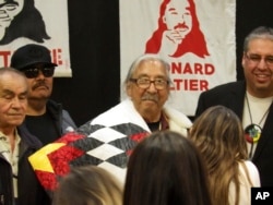 Leonard Peltier, center, a Native American activist released from a prison where he had been serving a life sentence in the 1975 killings of two FBI agents, dons a star quilt during a welcome event on the Turtle Mountain Reservation in North Dakota, Feb. 19, 2025.