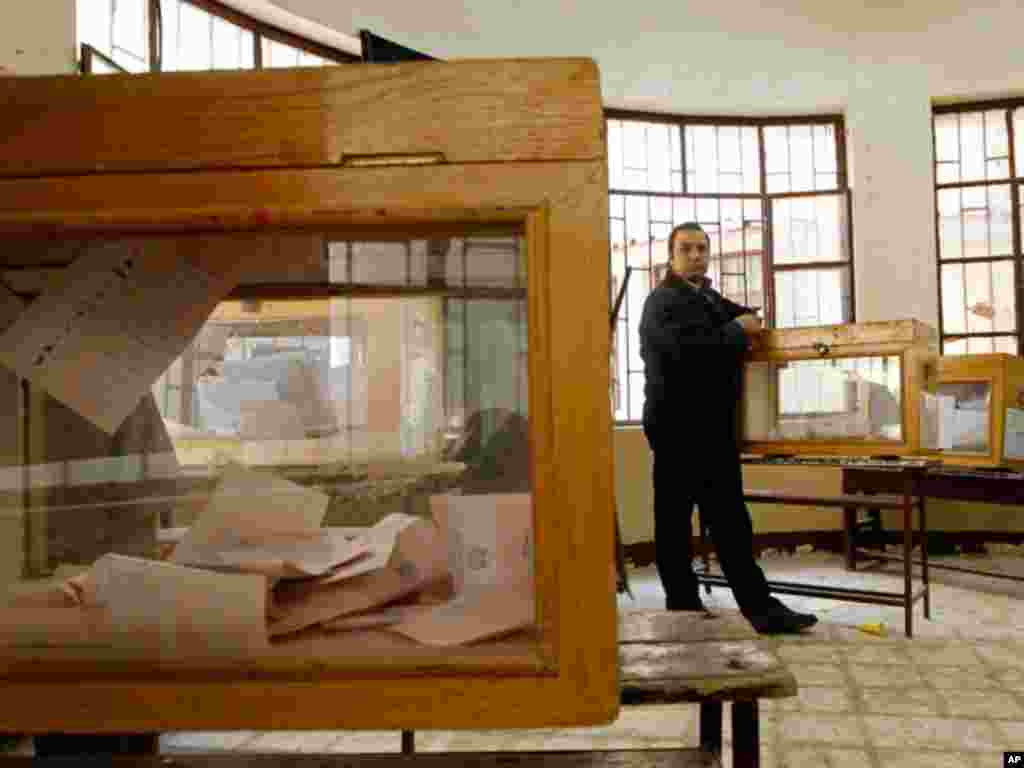 An electoral worker stands next to a ballot box in a polling station in Cairo. (Reuters)