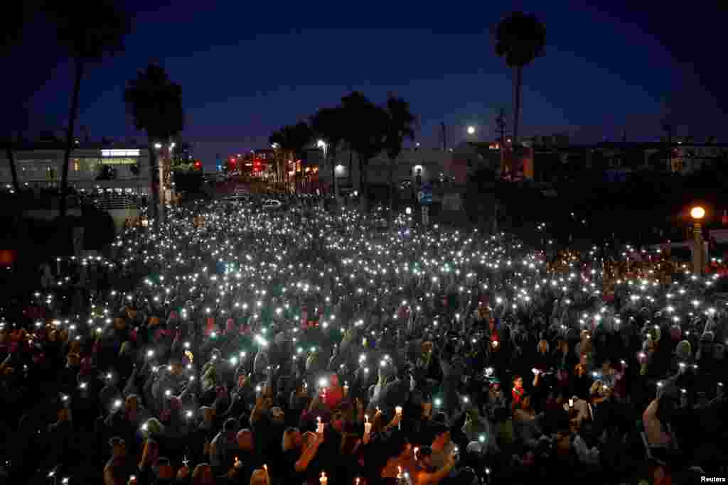 People hold candles and flashlights during a memorial for Rachael Parker and Sandy Casey, Manhattan Beach city employees and victims of the October 1st Las Vegas Route 91 music festival mass shooting, in Manhattan Beach, California, Oct. 4, 2017.