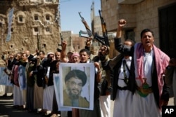 FILE - Shi'ite rebels, known as Houthis, hold a poster of Hezbollah leader Sheikh Hassan Nasrallah during a rally in support of Iranian-backed Hezbollah, in Sana'a, Yemen, March 3, 2016.