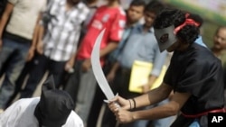 Members of Magic Movement, a group of young Bangladeshis, stage a mock execution scene in protest of Saudi Arabia beheading of eight Bangladeshi workers in Dhaka October 15, 2011.