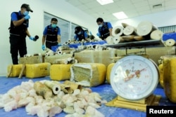 FILE - Thai forensic experts collect DNA samples from a confiscated elephant tusk, coming from Malawi, at Suvarnabhumi International Airport in Bangkok, Thailand, March 7, 2017.