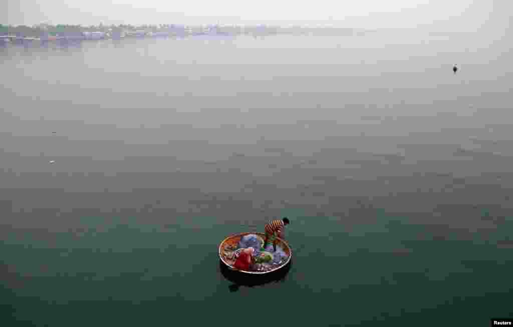 A fisherman and his wife catch fish in the waters of Vembanad Lake in Kochi, India.