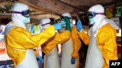 Wafanyakazi wa afya wa Guinea wakiwa na nguo za kujikinga katika kituo cha kutibu Ebola karibu na hospitali kuu ya Donka huko Conakry Sept. 25, 2014. 