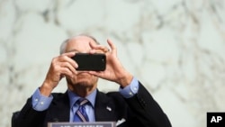 FILE - In this Monday, Oct. 12, 2020 file photo, Sen. Chuck Grassley, R-Iowa, uses his smartphone during a hearing on Capitol Hill in Washington. (Erin Schaff/The New York Times via AP, Pool)