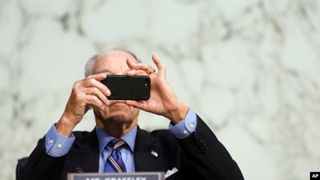 FILE - In this Monday, Oct. 12, 2020 file photo, Sen. Chuck Grassley, R-Iowa, uses his smartphone during a hearing on Capitol Hill in Washington. (Erin Schaff/The New York Times via AP, Pool)