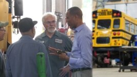 Tashitaa Tufaa chats with mechanics and drivers at Metropolitan Transportation Network’s maintenance shop in Fridley, Minnesota, Aug. 10, 2017.