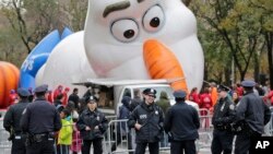 Petugas kepolisian berdiri dekat balon raksasa karakter Olaf dari film animasi "Frozen" yang sedang diisi gas untuk Parade Hari Bersyukur atau Thanksgiving di New York, 22 November 2017.