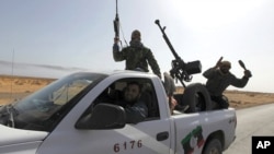 Rebels travel in a convoy on their way to Sirte city near Bin Jawad, March 28, 2011