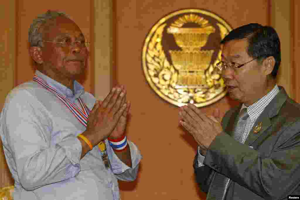 Newly elected Senate Speaker Surachai Liengboonlertchai (right) and anti-government protest leader Suthep Thaugsuban greet each other in parliament, Bangkok. May 12, 2014.