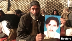 A member of Pakistan's Pashtun community holds a picture of Naqibullah Mehsud, whose extrajudicial killing by Karachi police in January sparked nationwide protests. 