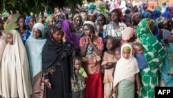 FILE - Refugees from Central Africa wait in Garoua Boulaye, Cameroon, for food and clothes delivered by humanitarian associations, April 25, 2014. 