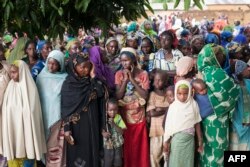 FILE - Refugees from Central Africa wait in Garoua-Boulai, Cameroon, for food and clothes delivered by humanitarian associations, April 25, 2014.