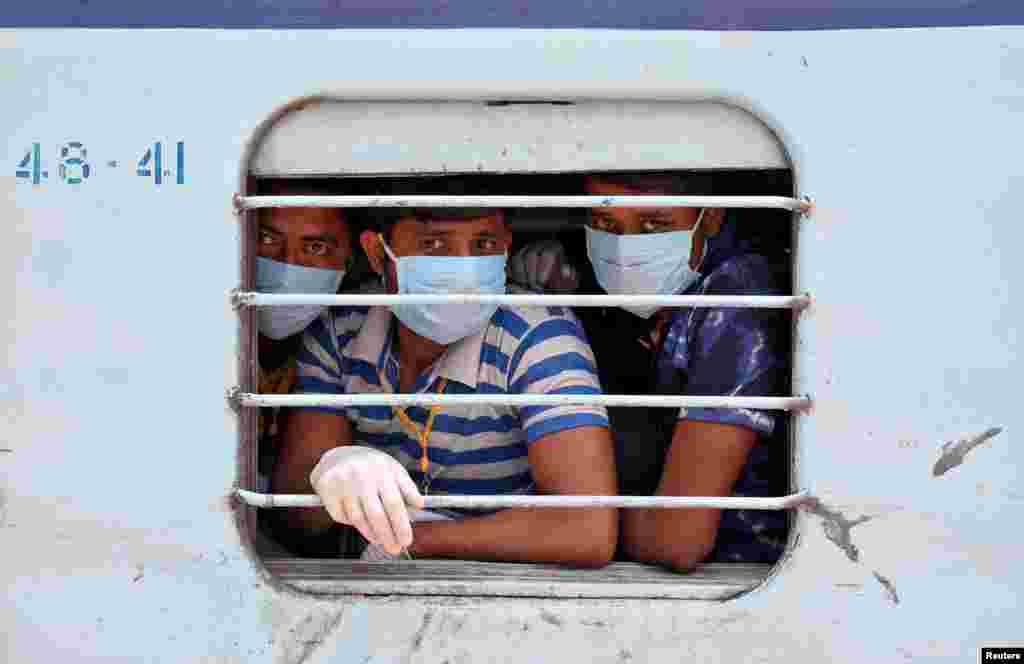 Migrant workers, who were trapped in the western state of Rajasthan due to a coronavirus lockdown, look out from a train upon their arrival in their home state of eastern West Bengal, India.