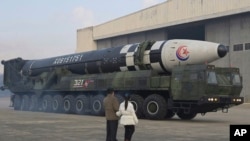 2022年11月18日，朝鲜领导人金正恩(左)和他的女儿在平壤国际机场视察火星-17洲际弹道导弹。（照片由朝鲜政府提供） 