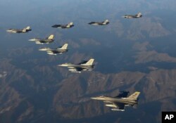 2022년 11월 18일 대한민국에서 합동 공중훈련을 하는 동안 대한민국 공군 F-35 전투기 4대(왼쪽 위)와 미 공군 F-16 전투기 4대가 대한민국 상공을 비행하고 있다. 사진 제공: 국방부. 대한민국 수비.