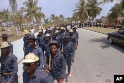 FILE - Tonton Macoutes march in downtown Port-au-Prince in support of Haiti's President Francois Duvalier, April 27, 1970.