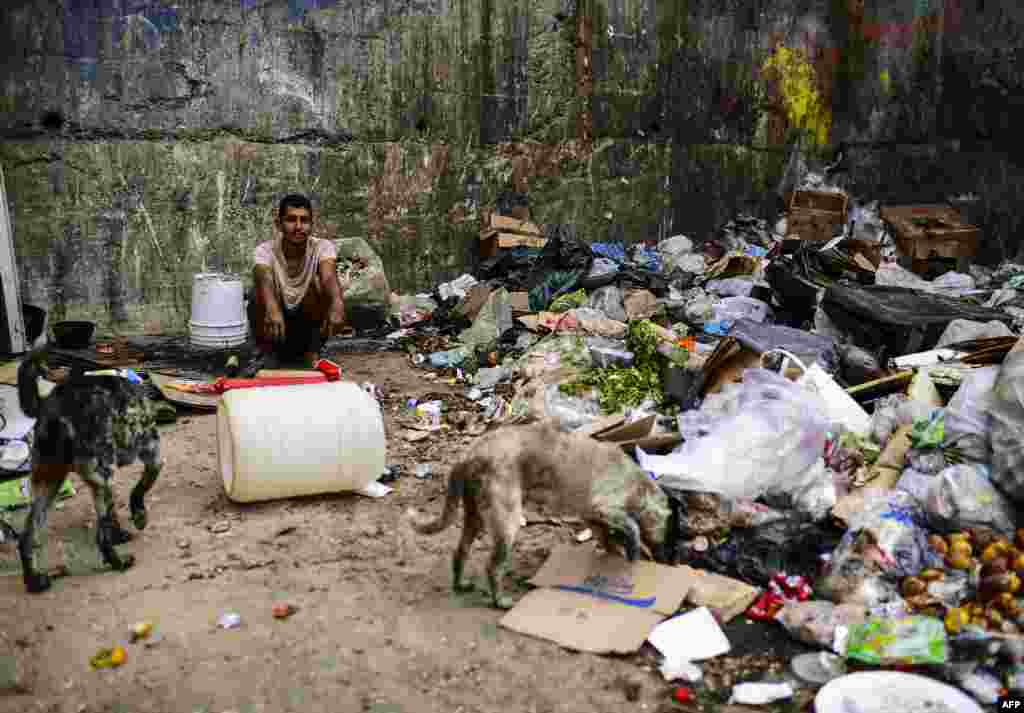A man waits to get some food at a garbage dump in Las Minas de Baruta neighborhood, Caracas, Venezuela.