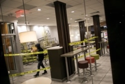 A man walks out of a McDonald's restaurant with his bag of food in the Brooklyn borough of New York, where the seating area has been cordoned off to its customers and only take out is available, March 18, 2020.