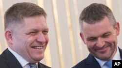 FILE - Outgoing Slovakian Prime Minister Robert Fico (L) and his replacement as new prime minister, Peter Pellegrini, smile at the Presidential palace in Bratislava on March 15, 2018.