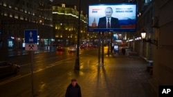 A man walks past a Russian President Vladimir Putin's campaign poster reading 'Strong president - strong Russia' and 'Presidential elections will be held in Russia in March 18' in Moscow, Jan. 15, 2018.