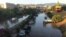 Cars are piled as others remain trapped in water and mud after an underpass, seen in the background, flooded on Wednesday in the Sicilian city of Palermo, southern Italy, as seen early on July 16, 2020.