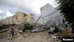 A man walks near damaged buildings, in the aftermath of Israeli strikes on Beirut's southern suburbs, Lebanon, Oct. 1, 2024. 