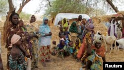 FILE - Nigerian refugees, who fled into Niger following attacks on their village, stand in the yard of their Nigerien host, in Diffa, southeastern Niger, June 21, 2016.