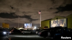 FILE - People inside their cars watch a movie at a drive-in theater while keeping social distancing rules amid the coronavirus pandemic, in Fort Lauderdale, Florida, March 28, 2020.