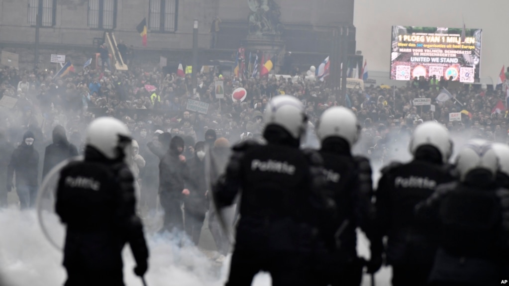 Polisi di Belgia berusaha membubarkan para demonstran yang memprotes kebijakan terkait COVID-19 di Brussel, hari Minggu (23/1). 