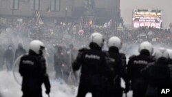 Polisi di Belgia berusaha membubarkan para demonstran yang memprotes kebijakan terkait COVID-19 di Brussel, hari Minggu (23/1). 