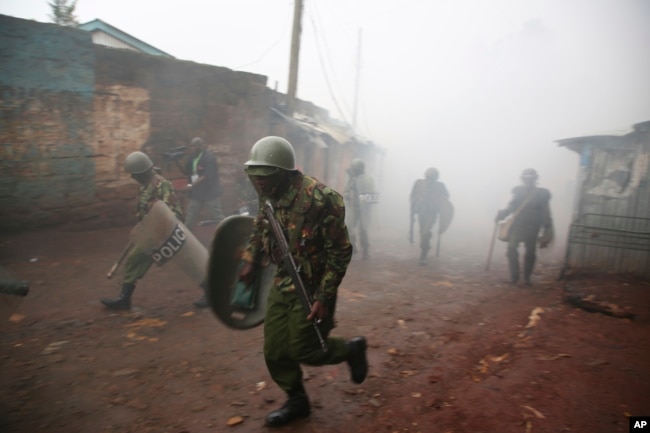 Riot police are caught in tear gas during running battle with opposition supporters in Kibera Slums in Nairobi, Kenya,Oct. 26, 2017.