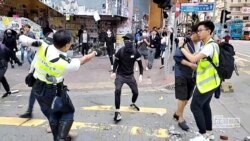 11일 홍콩 도심에서 경찰이 반정부 시위대 참가자를 향해 총을 겨누고 있다.