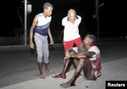 A Somali man injured in a night car bomb attack near a hotel in Hamarweyne district sits along a sidewalk near the scene in capital Mogadishu, Somalia, Feb. 26, 2016