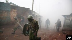 'yan sandan kwantar da tarzoma suna gudun bayan watsa barkonon tsohuwa yayin arangama da masu zanga zanga a Kibera, Nairobi, Kenya,Oct. 26, 2017. 