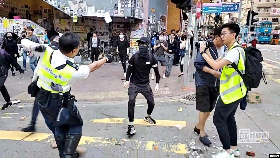 Seorang polisi menodongkan pistolnya ke seorang pengunjuk rasa di Sai Wan Ho, Hong Kong, 1 November 2019. 