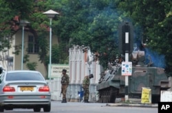 A military tank is seen with armed soldiers on a road leading to President Robert Mugabe's office in Harare, Zimbabwe, Nov. 15, 2017.