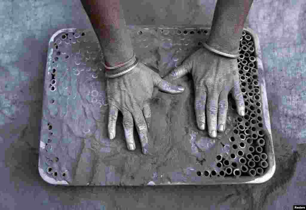 A worker fills small paper rolls with gunpowder mixture to make firecrackers at a factory ahead of Diwali, the Hindu festival of lights, on the outskirts of Ahmedabad, India.