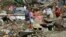 A typhoon survivor stands on rubbish in Tacloban, central Philippines, Dec. 8, 2013.