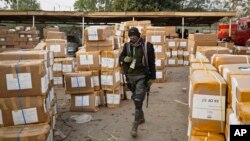 FILE - A police officer keeps guard over electoral materials still stacked in boxes at the offices of the Independent National Electoral Commission in Kano, in northern Nigeria, Feb. 16, 2019. 