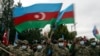 FILE - Azerbaijani soldiers wave national flags after the transfer of the Lachin region to Azerbaijani control, part of a peace deal requiring Armenia to cede Azerbaijani territories it held outside Nagorno-Karabakh, Dec. 1, 2020.